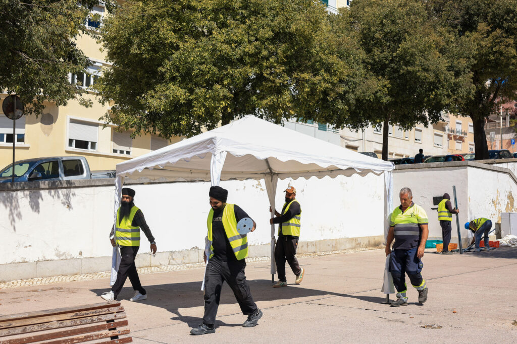 TLG Foundation and Casa da Índia volunteers in turbans setting up a tent ahead of Festival Gandhi 2026